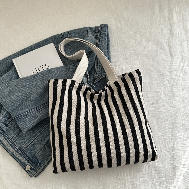 The new cross-border vertical striped commuter tote bag, hand-held shoulder bag, is fashionable and has a large capacity. It features an InS-style simple letter sail undefined