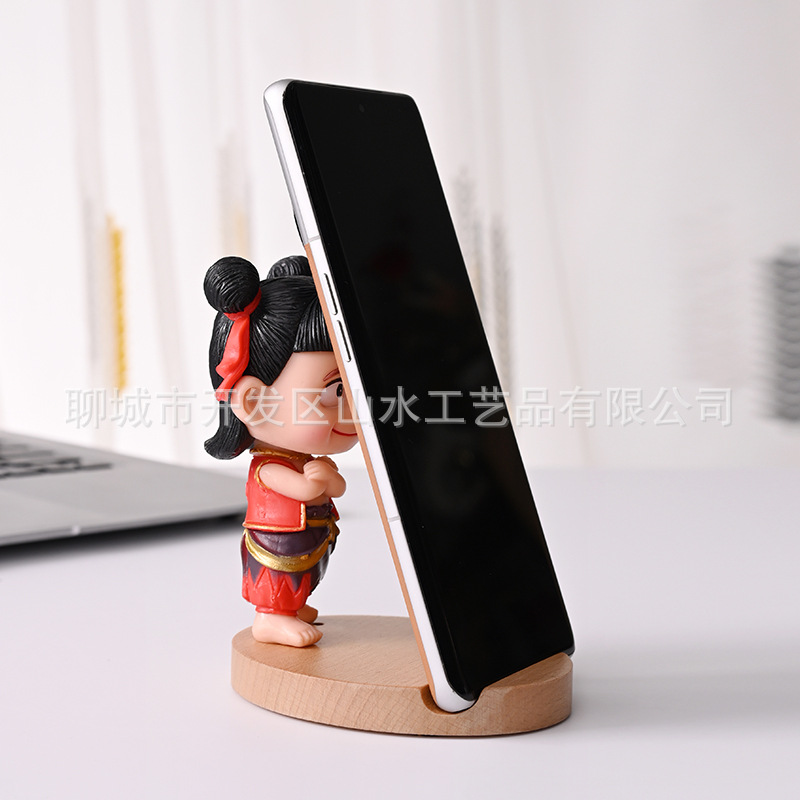La celebridad de Internet Nezha's Devil Boy Naohai, el soporte para teléfono móvil que rodea el mundo, el soporte para teléfono móvil de madera Nezha Lingzhu, decoración de escritorio