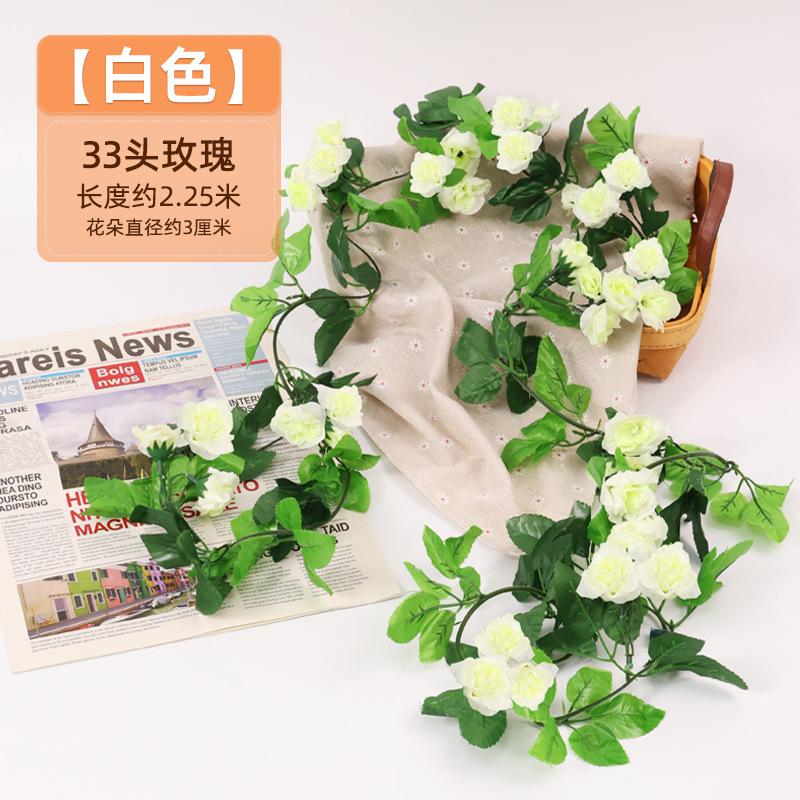 Simulación de flores falsas rosas de caña colgando la pared tubería de drenaje envuelta hoja verde que cubre la parte superior de la decoración de boda de plástico