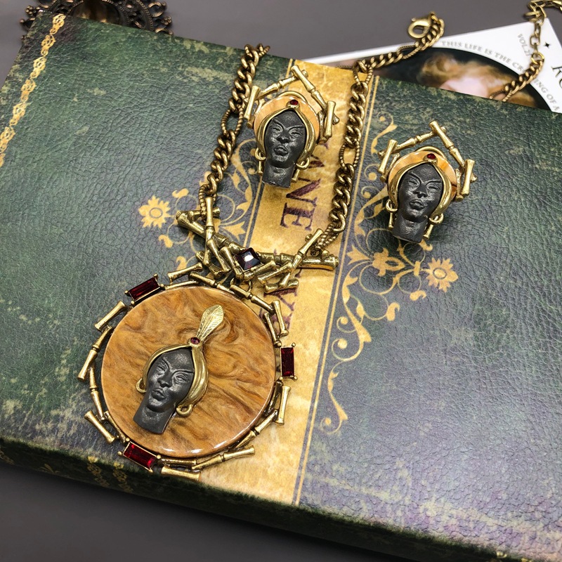 A set of embossed human head necklace and earrings with a retro European and American style, featuring an antique gold finish and an elegant and sophisticated feel.