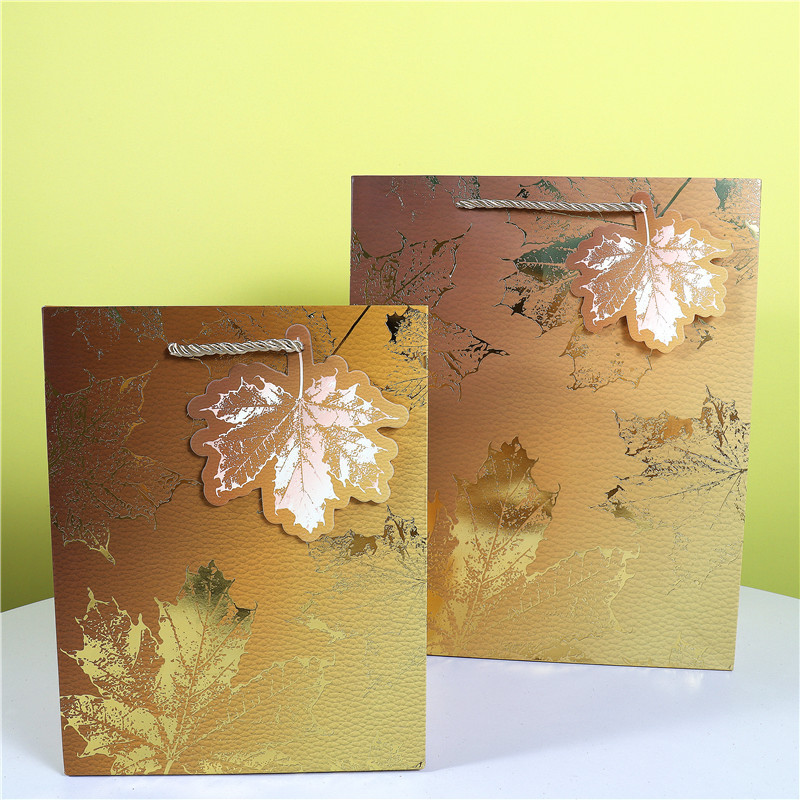 3D贴片蝴蝶结白卡手提纸袋子现货批发树叶带吊卡包装袋烫金四叶草