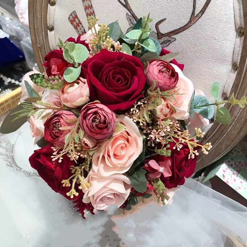 手に花を持つ新婦の韓国式結婚式の領収書のシミュレーションの花束の森系のウェディングドレスの撮影の道具の手に花をささげます。|undefined