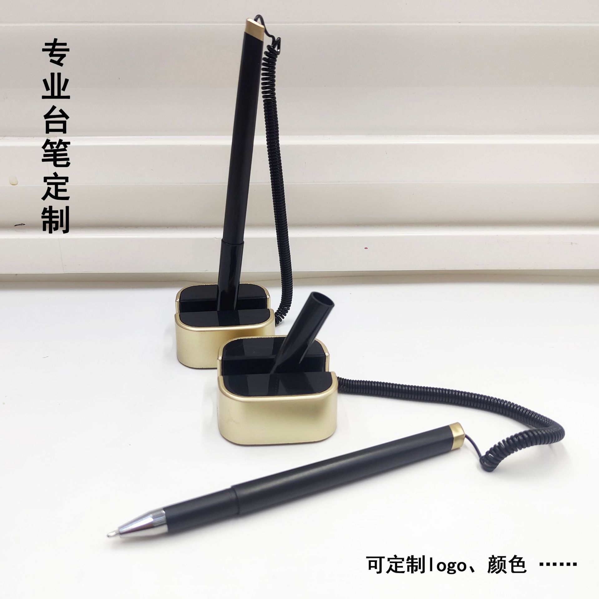Luxury black pen with gold trim and a square base, suitable for business reception areas; features a spring-loaded cord to prevent loss and can be customized with a logo