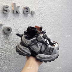 左左の家の屋外の子供は古い登山靴をします。