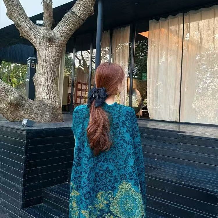 ピーコックの青いストールの外で女性の雲南新疆のチベットの大西北の旅行は写真を撮る民族風のマントを着ます。|undefined