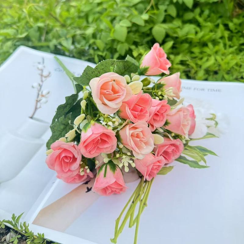 模造花ミニバラは花を手にして家にいる結婚式の室内客間の装飾に造花を飾っている|undefined