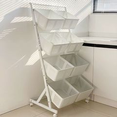 寝室の物置棚が床に落ちた多層の野菜かごの客間の家庭用カートの間食収納かごの果物野菜棚