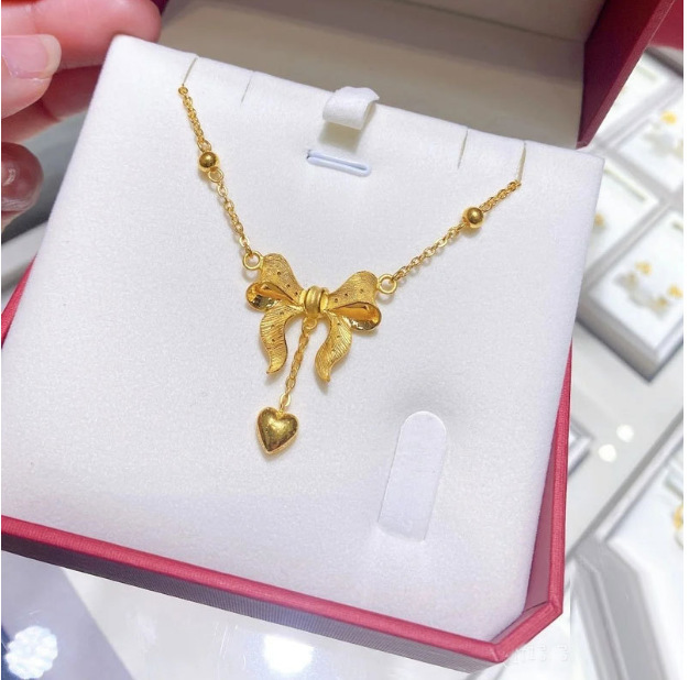Collana con pendente a cuore e fiocco con nappe dorata_voghion.com