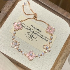 絶妙なダイヤモンドがちりばめられた光沢のある模造天然ピンクシェル中空幸運の四つ葉のクローバー引き出しブレスレット女性のニッチライト高級ハンドジュエリー