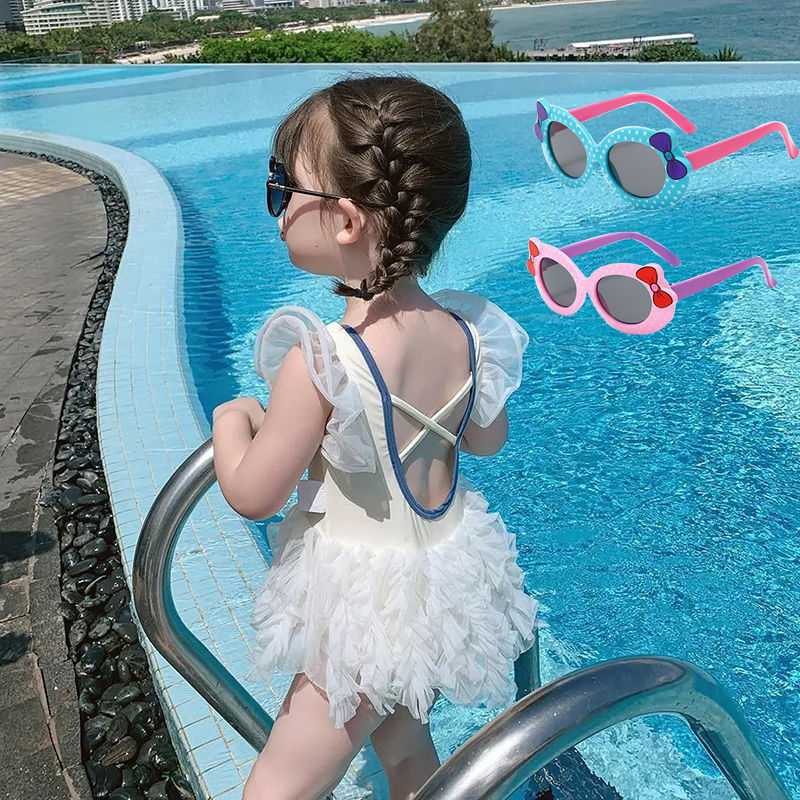 Niña bañador beige con gafas de sol