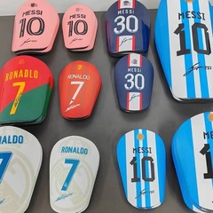 球星miniサッカーのレギンスの靴下は成人の子供の炭素繊維の梅西の厚い保護板の運動の保護具の卸売りをカバーします。