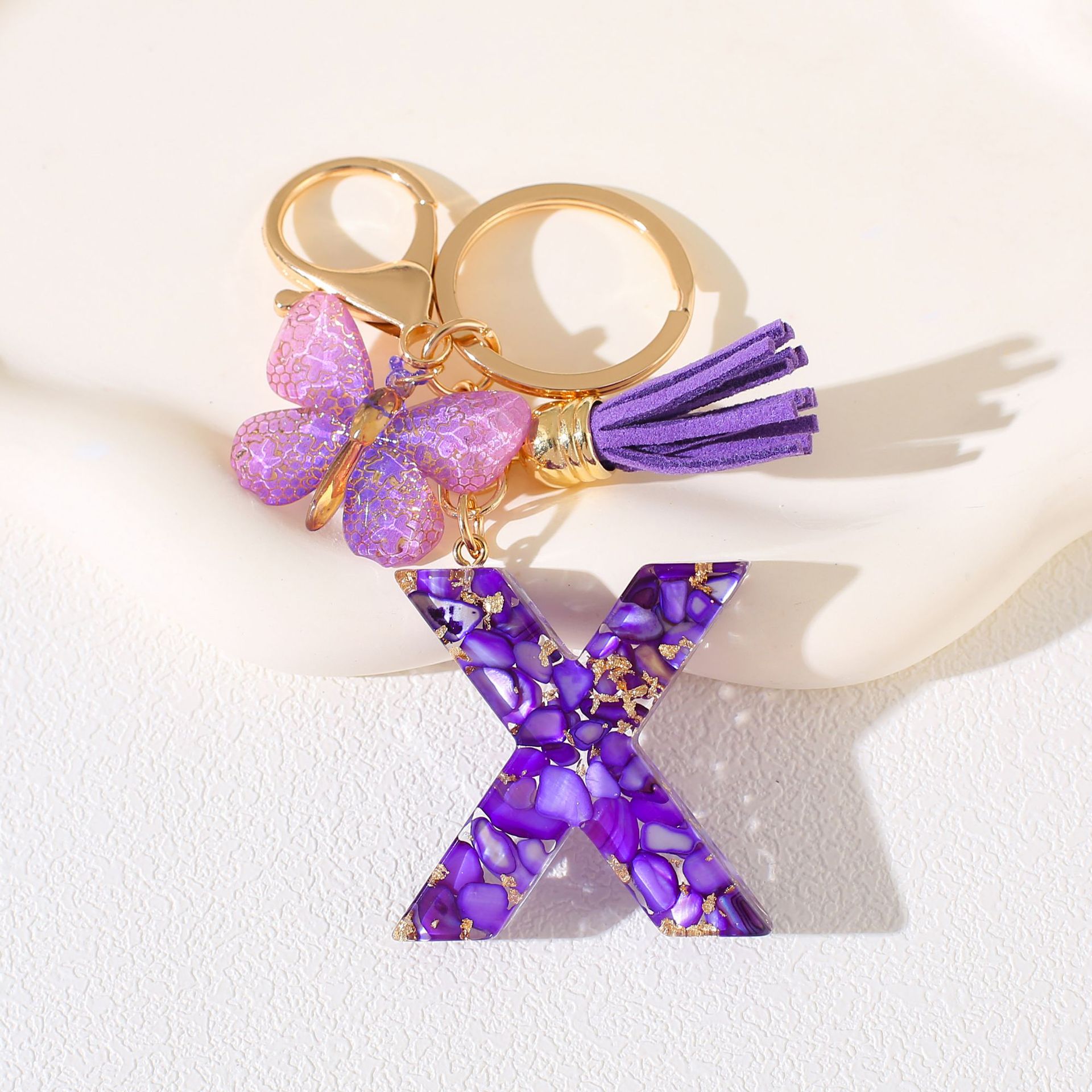 Fábrica directa de Yiwu accesorios de resina de goteo de embalaje llavero anillo de metal letras mariposa brilla colgante damas