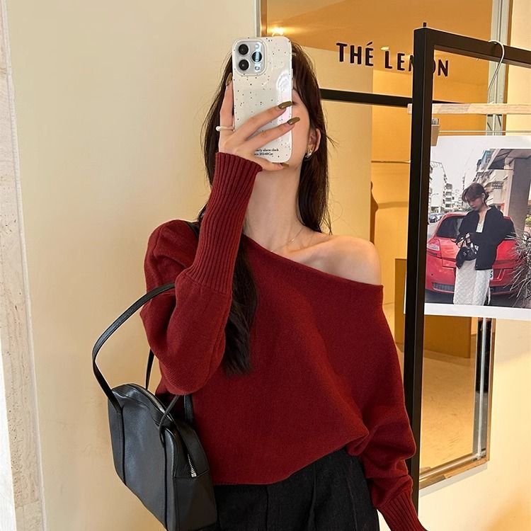 柔らかいピンクの不規則な長袖の斜めの肩のセーターの女性の秋冬の新型の修身の美しい露肩のchiのニットの上着
