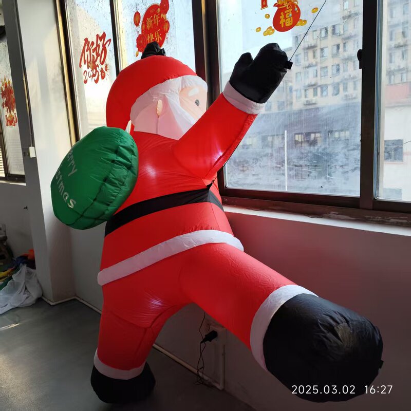 国境を越えた3メートルの壁に登るサンタクロースの空気型グリーンバックパッククリスマスの空気型老人の空気型|undefined