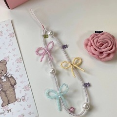 赤い本の同じタイプの蝶結びの手作りのinsの携帯のチェーンは縄を掛けます。