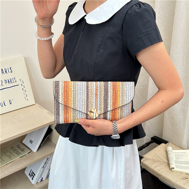 2026 verano nuevo color a rayas de moda personalidad bolsa de sobres casuales femenina bolso de mano de diseño de estilo exterior