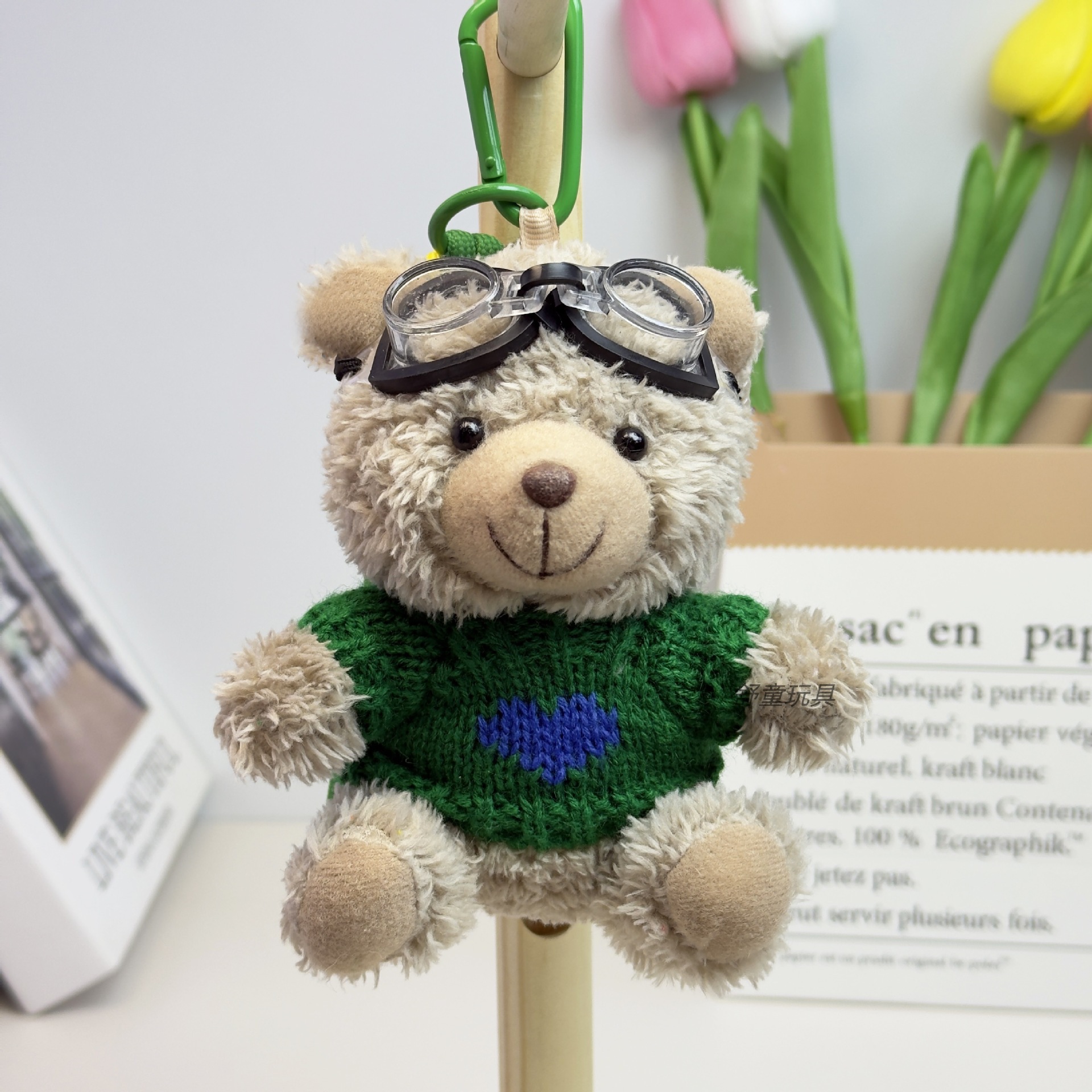 Oso con suéter verde y gafas de baño