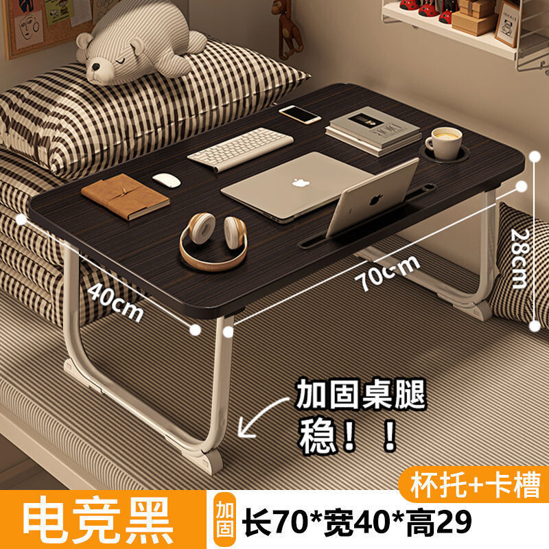 ベッドの上の小さい机のノートパソコンの机の上で折り畳みます。|undefined