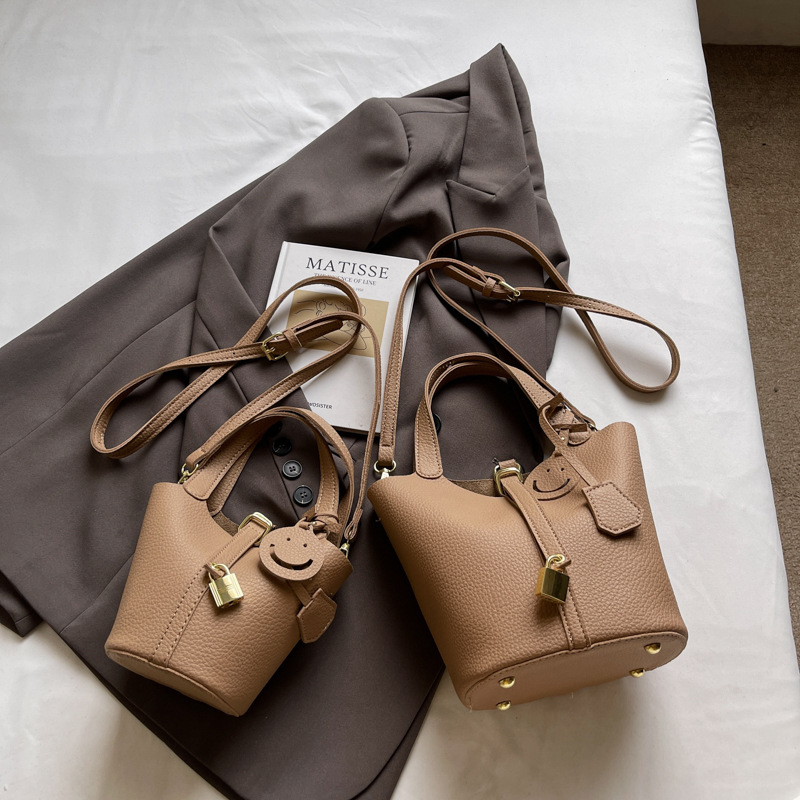 Bolso de cubo portátil con patrón de lichi de alta gama para mujer 2025 nuevo bolso de hombro de todo fósforo de moda bolso de mensajero casual de estilo occidental