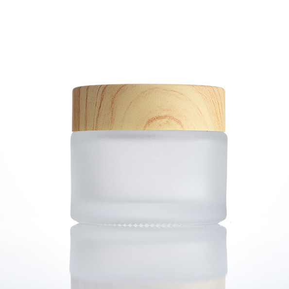 Botella de crema de vidrio al por mayor botella de crema de ojos esmerilada 100g cubierta de grano de madera cosmética sub-botella