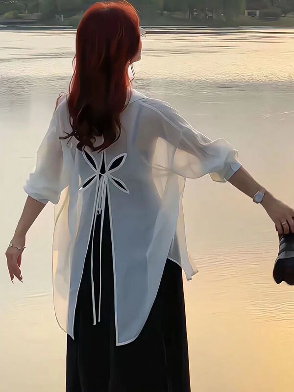 薄いタイプの微透長袖日焼け止めカーディガンの背中には、青いシャツ付きの女性夏のファッションカジュアルシャツのコートがあります。|undefined