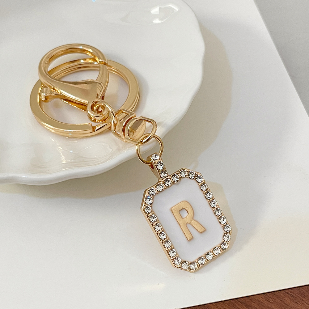 Nueva moda 26 cartas gota de diamante aceite llavero bolso del auricular pareja colgante vacaciones pequeño regalo al por mayor