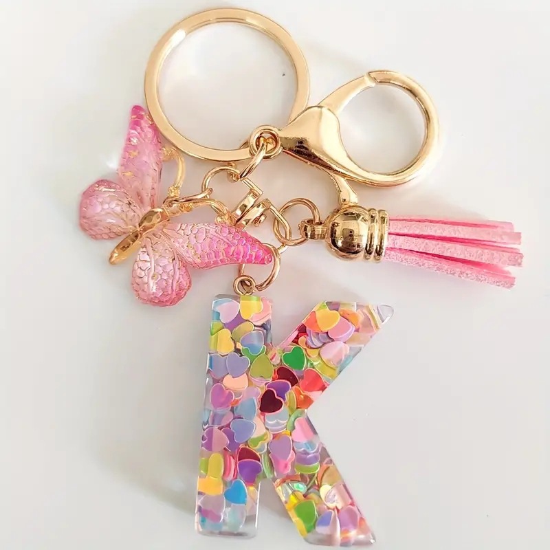 2024 transfronteriza en stock resina rosa con lentejuelas 26 letras inglesas llavero colgante mariposa borla Accesorios
