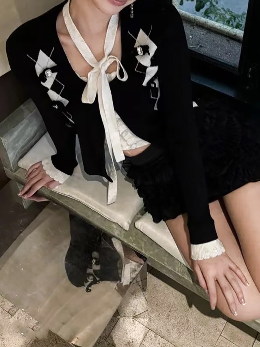 2025年の春の新商品のモダンな白黒の衝突色のリボンは菱格のニットの上着の秋のファッションの高級感をつなぎ合わせます。