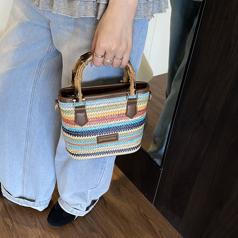 Bolsa de tejido de verano super caliente para mujeres 2025 nuevo juego de playa portátil bolso de balde arco iris tela de paja bolso de mochila para mujeres