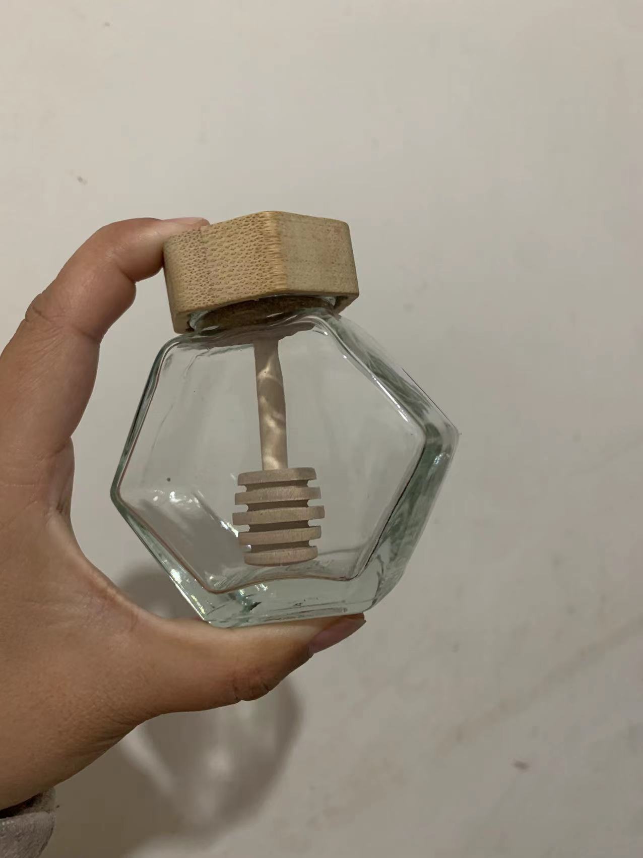 En stock botella de miel cubierta de bambú botella de vidrio hexagonal transparente con varilla de agitación sellada miel sub-botella gran cantidad consulta