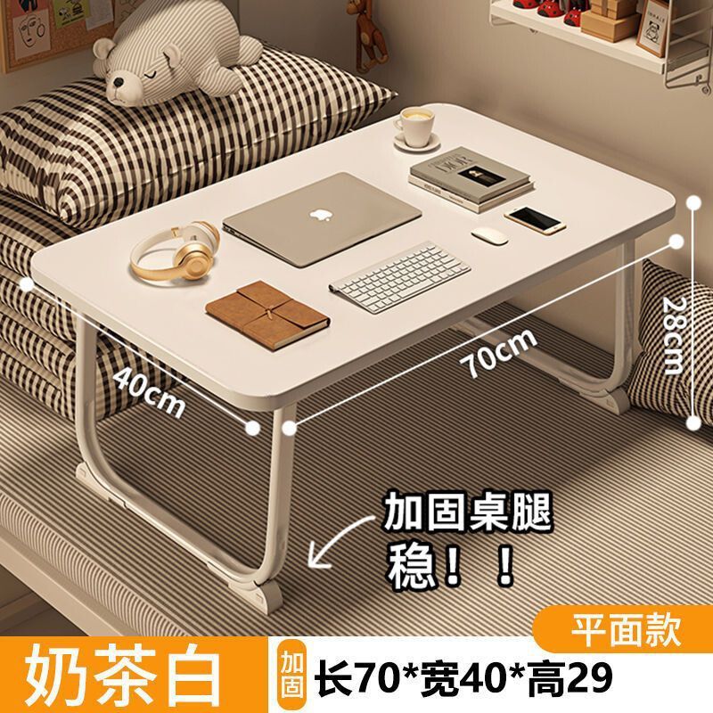 ベッドの上の小さい机のノートパソコンの机の上で折り畳みます。|undefined