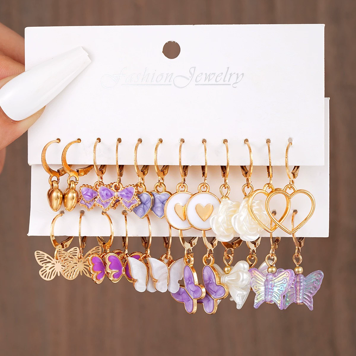 Pearl earrings set, gold‑tone multi‑pair on display card, assorted charm styles