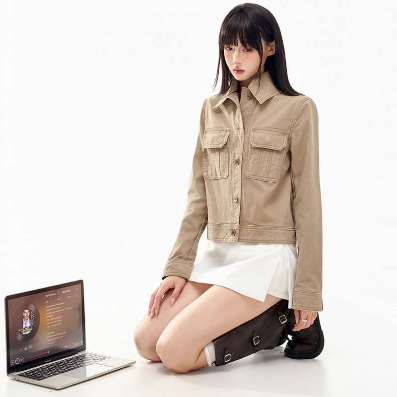 Short, loose-fitting denim jacket with distressed buttons and a washed finish.