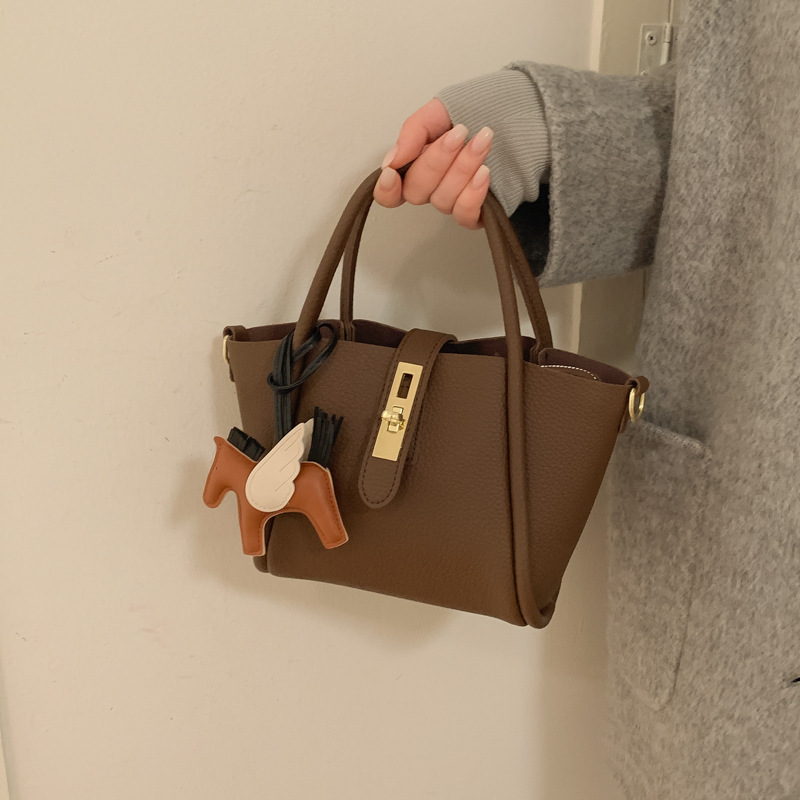 Bolsa de balde de agua de lichi estilo extranjero bolso de ocio coreano 2025 nuevo viaje de hombro mochila para mujeres