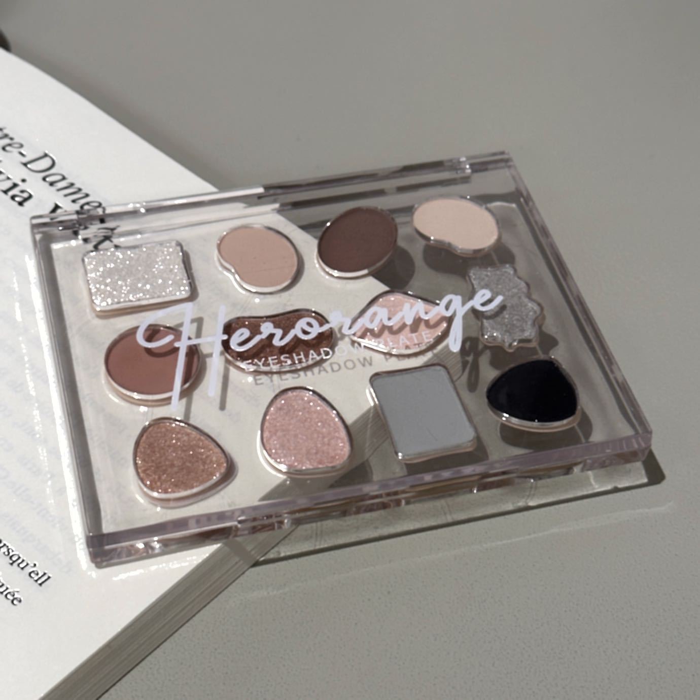 La paleta de sombras de ojos de alta calidad con carcasa transparente de 12 colores no es fácil de volar y duradera