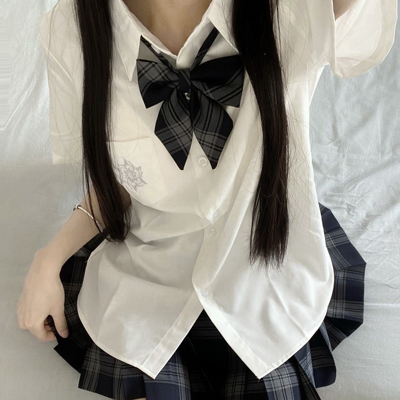 Белая рубашка с короткими рукавами и вышивкой.