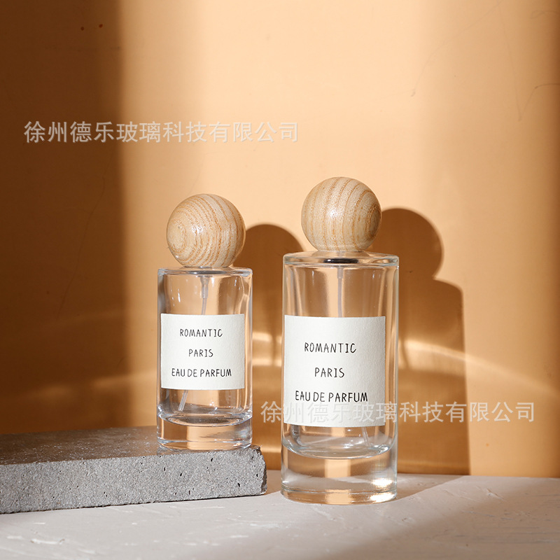 Venta al por mayor 50ml botella de perfume de vidrio cilíndrico botella de spray de perfume Cosméticos líquidos sub-botella con cubierta de bola de madera