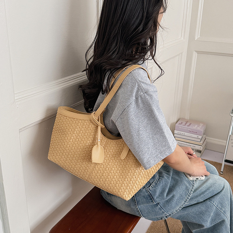 Verano 2026 viaje de viaje sensación de tejido versátil versátil nuevo bolso de mujer bolso cubo popular hombro único