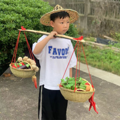 幼稚園の子供の小さい天びんの舞台の道具の子供は竹のかごのトランクの竹のおもちゃのゲームを演じます。