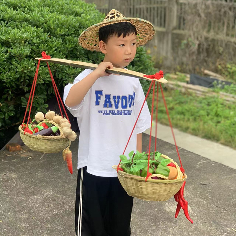 幼稚園の子供の小さい天びんの舞台の道具の子供は竹のかごのトランクの竹のおもちゃのゲームを演じます。|undefined