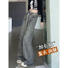 ズボンの女性の背の高い秋のレトロなジーパンを長くして、古い散歩をします。
