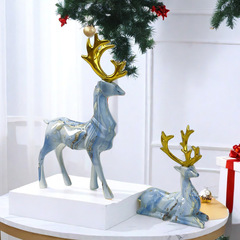クリスマスの創意カップルは鹿の置物の客間のテレビの棚の軽い贅沢な工芸品の家庭の装飾用品に対して引っ越して贈り物をします。