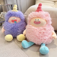 醜い萌えモンスターのぬいぐるみが枕を抱いてぬいぐるみの妖精の毛が生えている人形が彼女に誕生日プレゼントを贈る