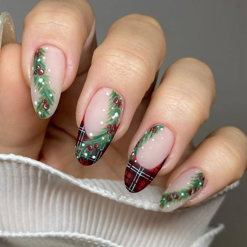 Christmas-themed hand-painted pine branch and berry nail art, featuring a retro red plaid pattern and oval-shaped nail tips, creating a festive and atmospheric nail look