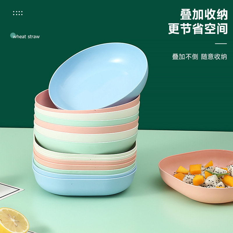骨の皿を吐く日本の家庭用創意プラスチックの食卓に野菜の皿を置いて骨の皿の小さい皿の果物のキャンディーの皿を吐く。|undefined
