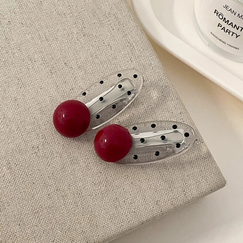 Un par de pinzas de perlas rojas