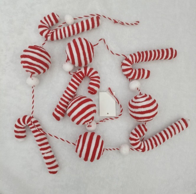 新しいクリスマス装飾品の祝日の雰囲気シーンにベルベットの縞模様の杖キャンディーがクリスマス帽を飾っている|undefined