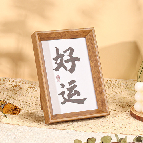 Vintage Chinese-style calligraphy and painting frame, decorated with a calligraphy scroll, suitable for desktop display, standing on a table, as a decorative gift item.
