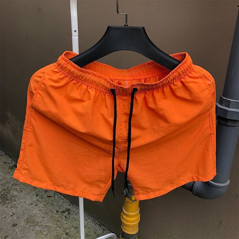 Pantalones de cuatro puntos Pantalones cortos casuales de verano para hombres Pantalones de playa de color caramelo para hombres de moda Pantalones de tres puntos deportivos sueltos de secado rápido