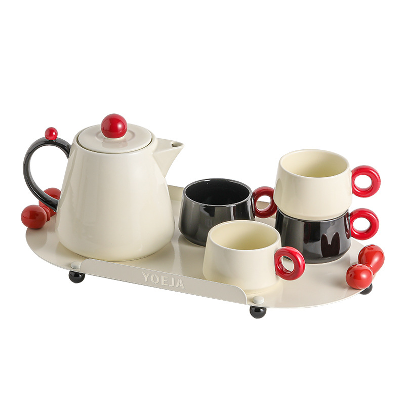 La ama de casa moderna es la misma creativa encantadora de alto valor de la cara con un conjunto de utensilios de agua de cerámica doméstica para invitados con un conjunto completo de tetera de té